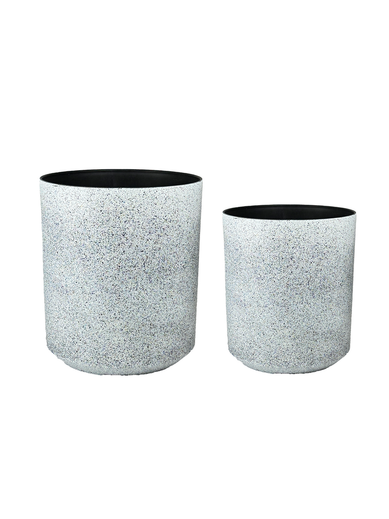 High-angle view of a speckled white planter with a minimalist cylindrical design, featuring a smooth matte finish and subtle texture. Its neutral tones complement various indoor and outdoor settings.
